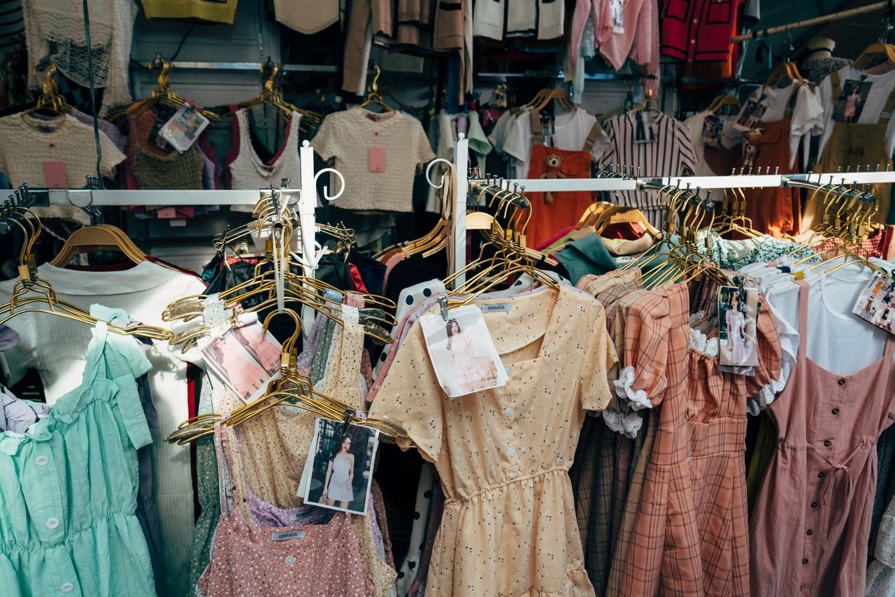 Home A colorful assortment of dresses hanging on a clothing rack in a trendy fashion boutique.