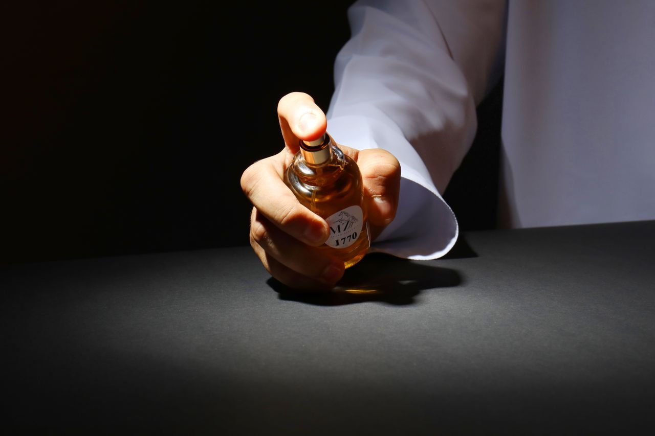 Crafting Captivating Headlines: Your awesome post title goes here A hand elegantly holding a perfume bottle against a dark backdrop, highlighting luxury fragrance.